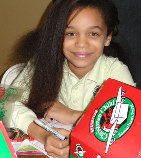 A Community Christian Academy student prepares an Operation Christmas Child shoebox