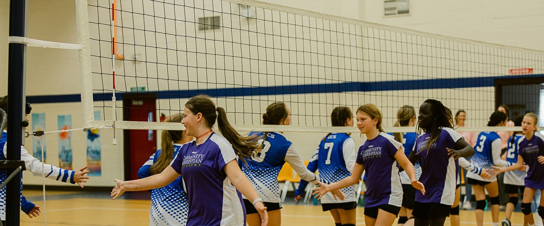 Community Christian Academy volleyball team members greet their opponents