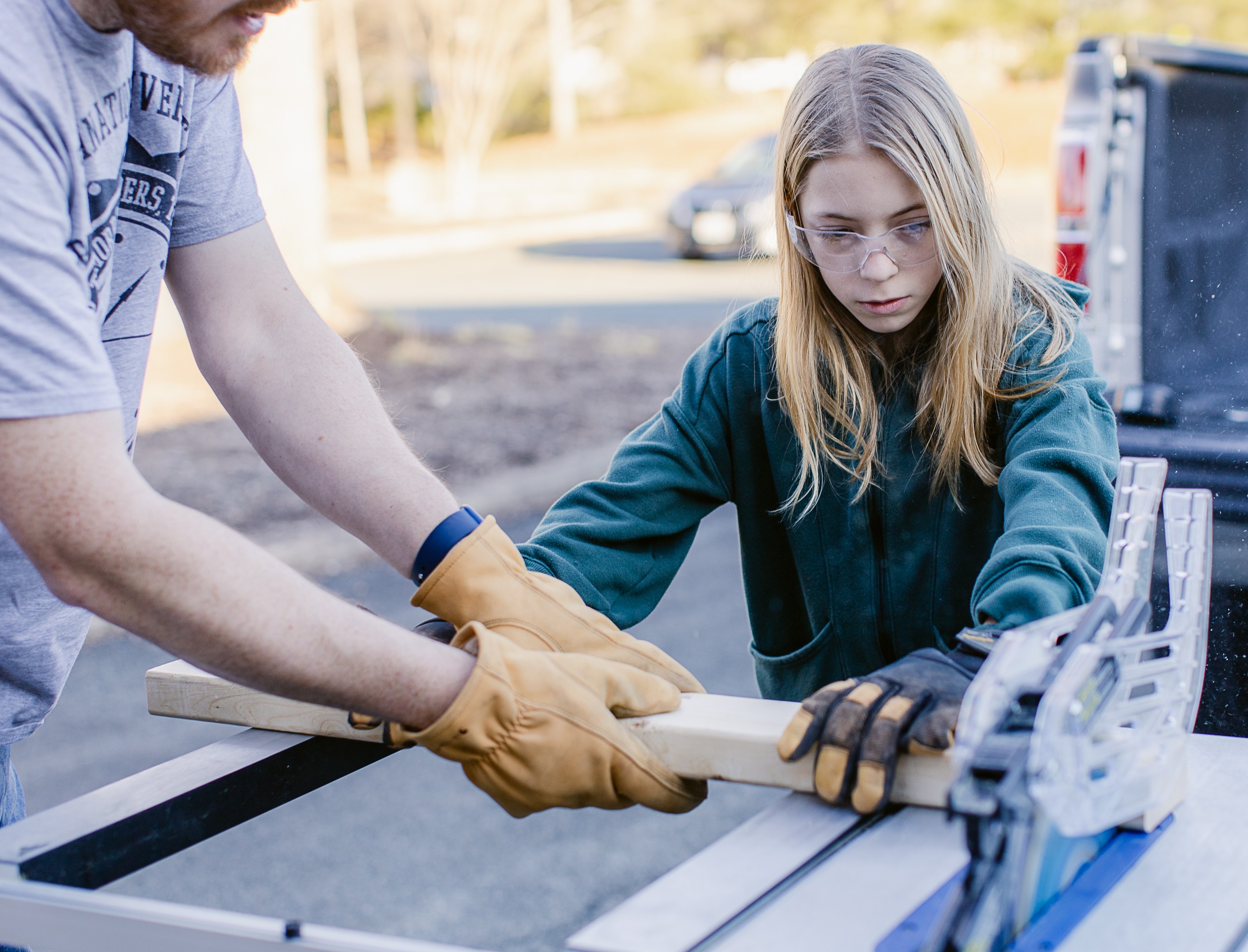 A young woman and a man are working with wood