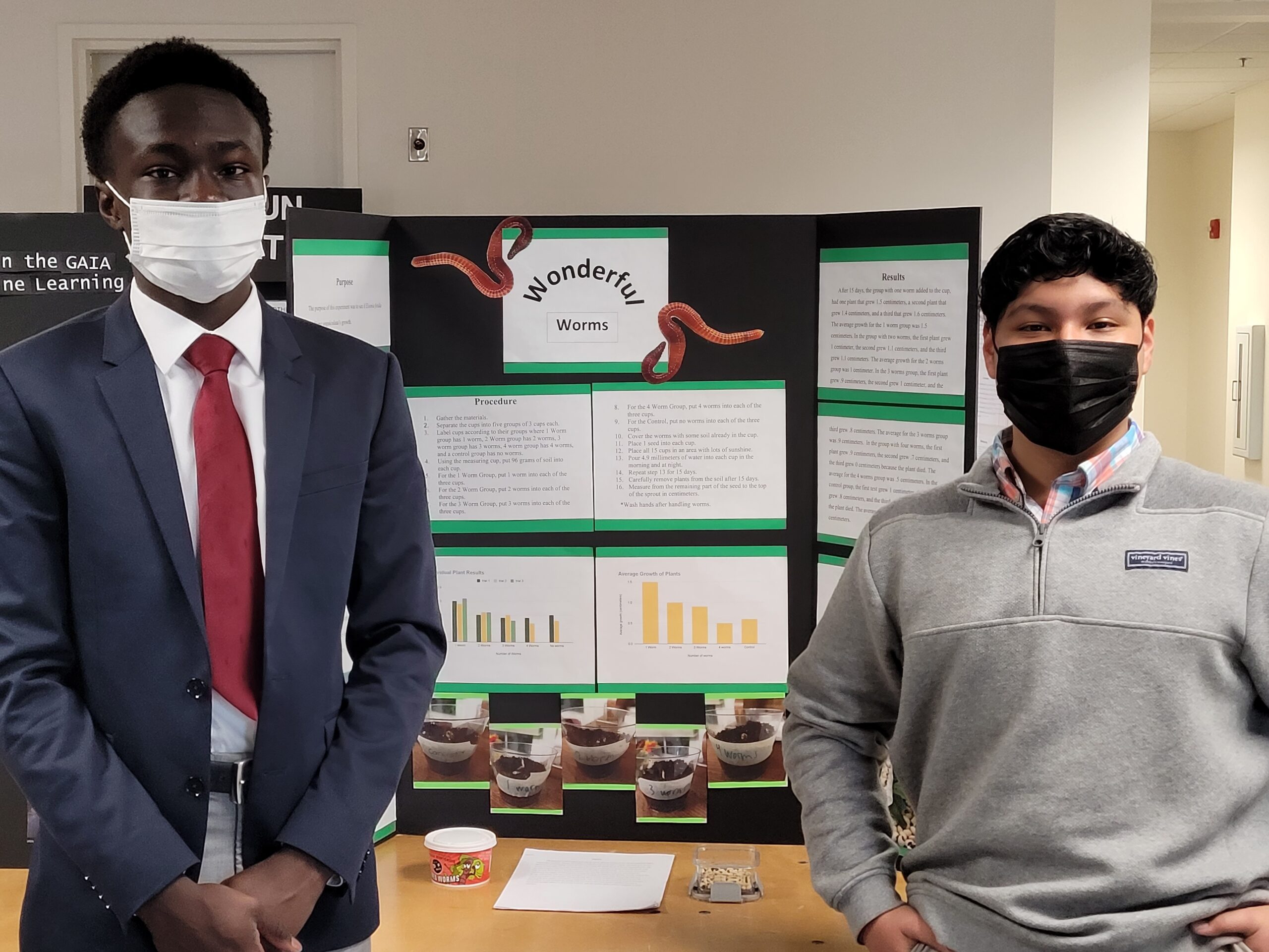 Two students stand in front of their science fair project