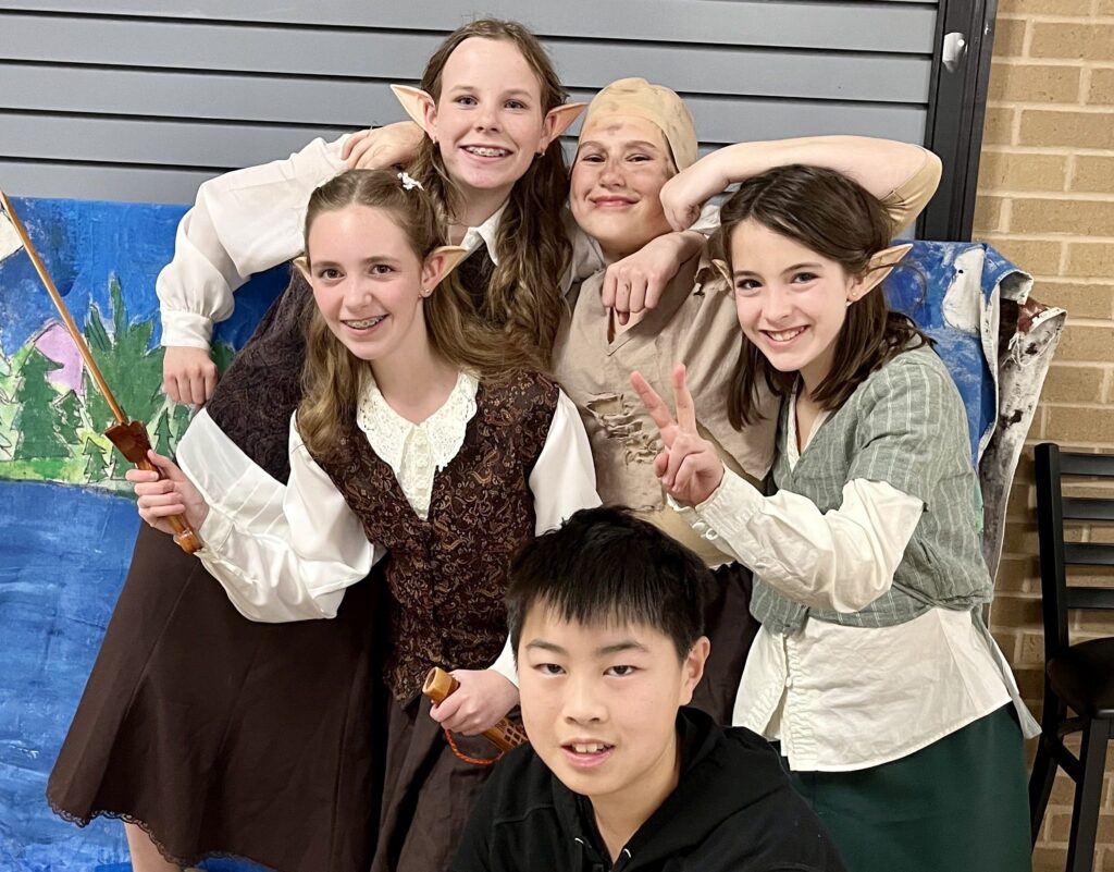 Students in elf costumes pose for a photo