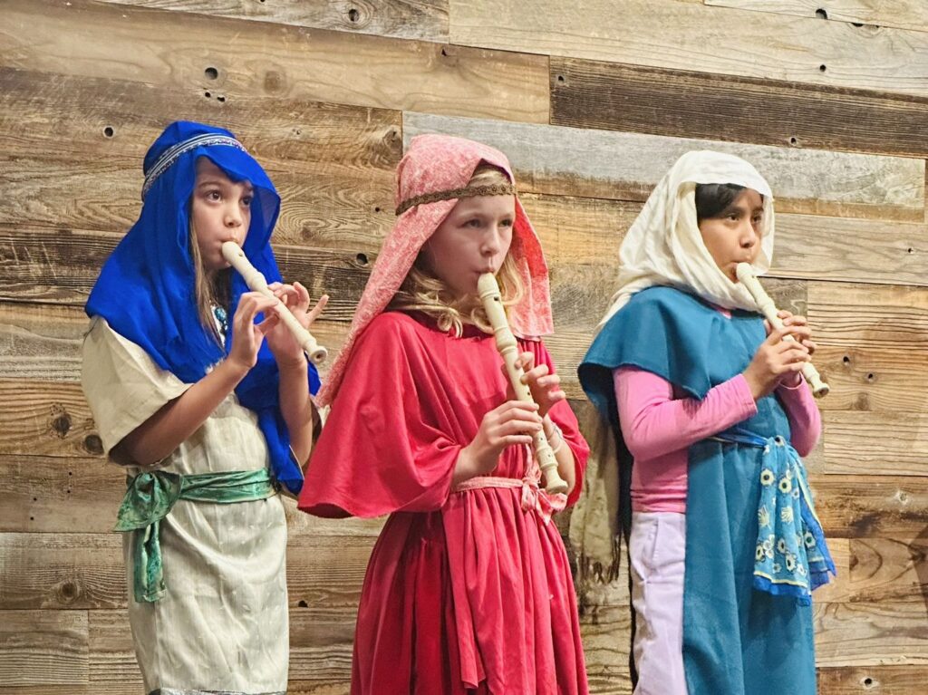 Three children play musical instruments