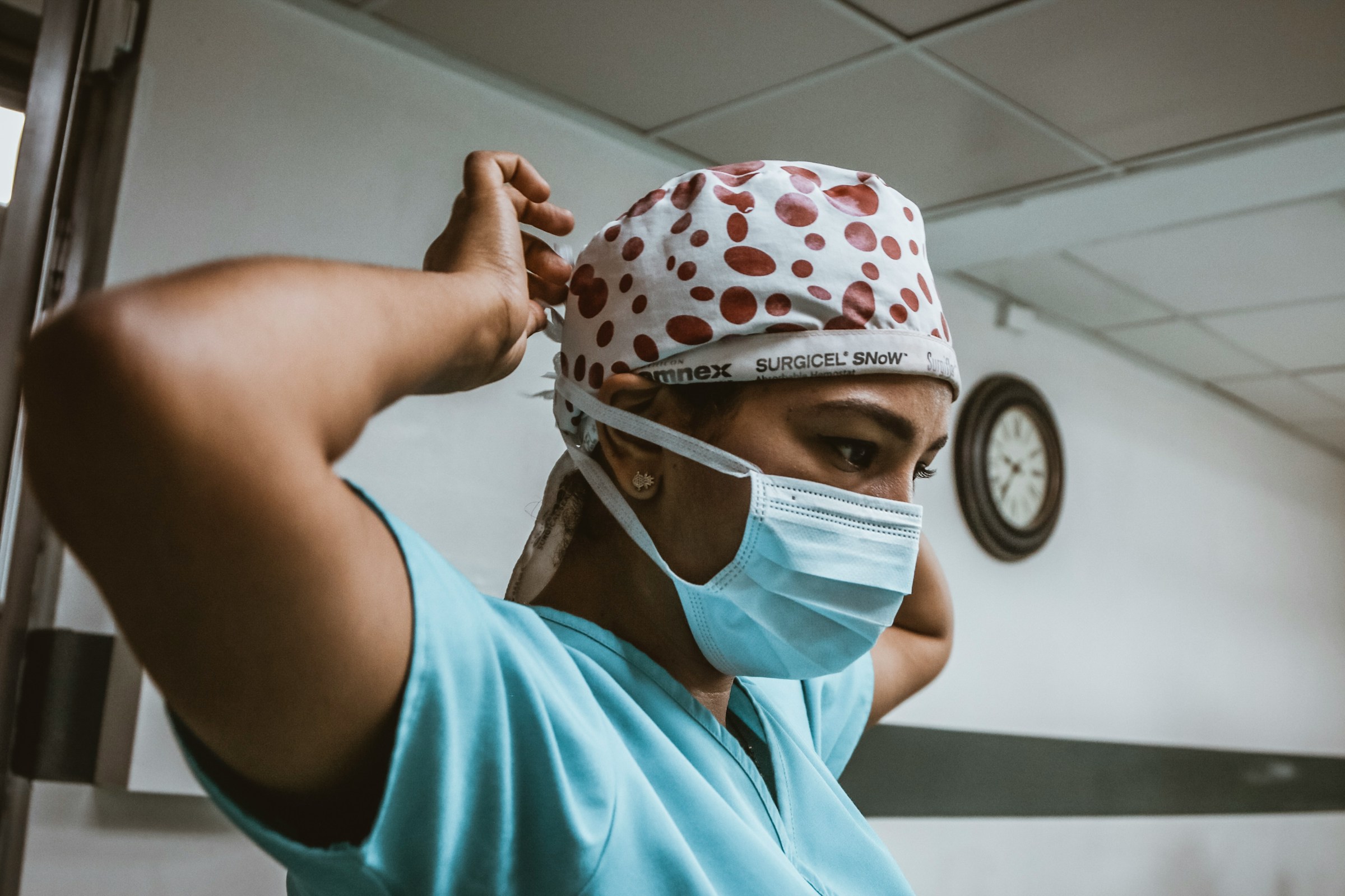 Person putting on a medical cap and mask
