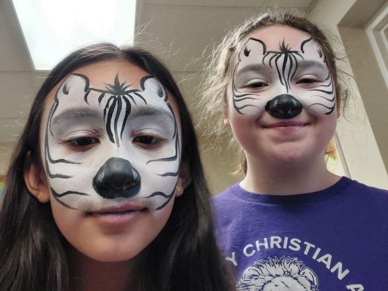 Two Community Christian Academy students show off their faces painted as animals