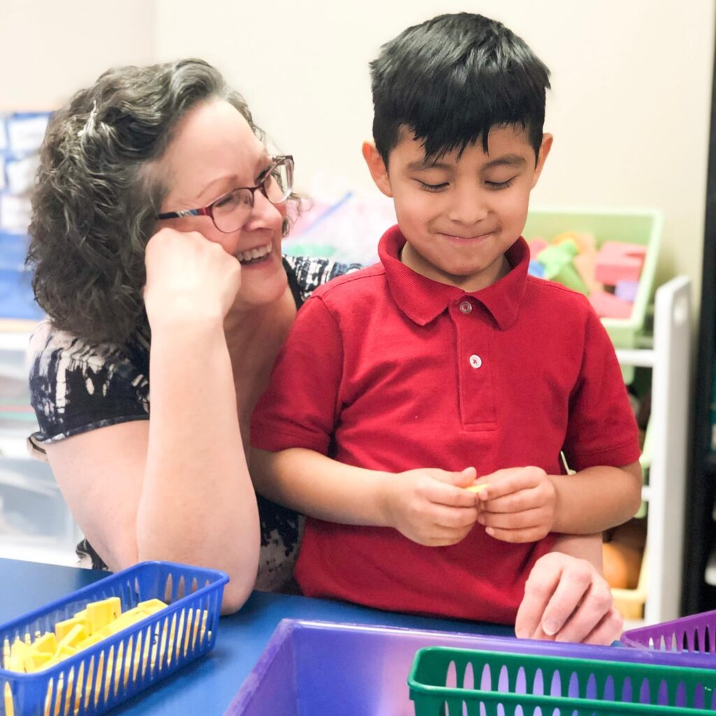 Teacher and student interact with learning materials.